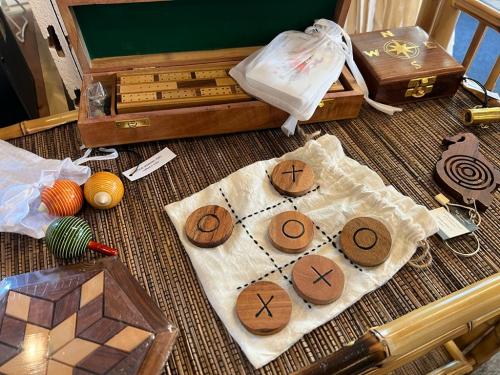 A wooden tic-tac-toe game on a cloth, surrounded by various crafts and a wooden box.