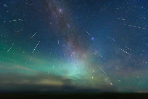 A stunning night sky filled with shooting stars and a vibrant display of the Milky Way galaxy.