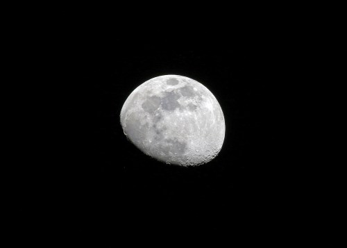 A close-up view of a crescent moon against a black sky, showcasing its craters and surface details.