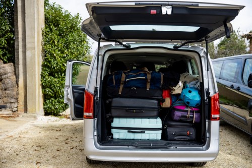 A packed car trunk filled with various bags and luggage, ready for a trip.