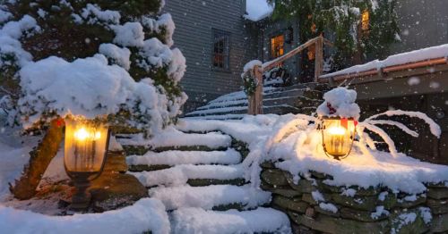 A snowy scene of a staircase leading up to a home