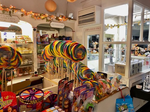 A colorful display of lollipops and various candies in a bright candy shop.