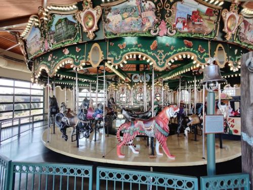 A colorful carousel featuring various painted animals, including a lion, under a decorative canopy.