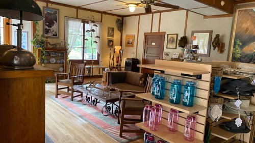 A cozy interior of a shop featuring wooden furniture, decor, and merchandise displays.
