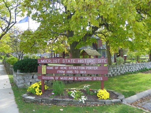 Sign for Limberlost State Historic Site, home of Gene Stratton Porter, surrounded by flowers and trees.