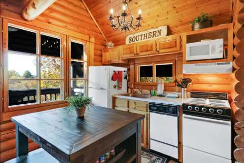 Cozy wooden kitchen with a rustic table, white appliances, and a "SOUTHERN" sign above the window.