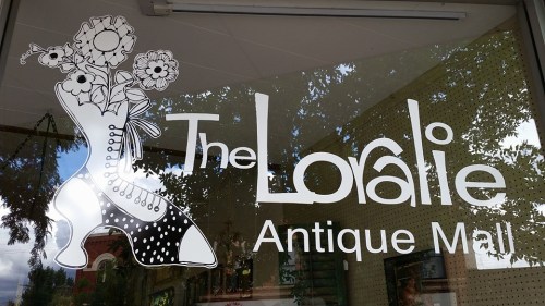 Sign for "The Loralie Antique Mall" featuring a decorative boot with flowers.