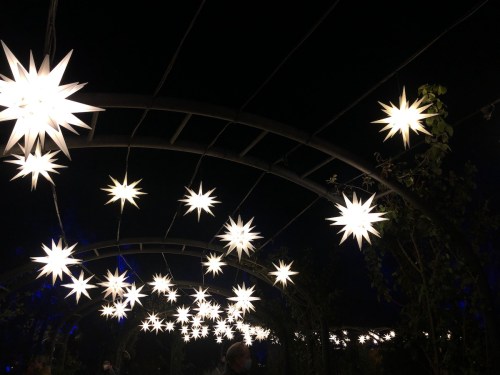 A dark setting illuminated by star-shaped lights hanging from an archway, creating a festive atmosphere.