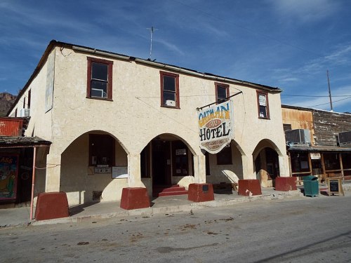 Historic building with arched entrances, featuring a sign that reads "Captain Hotel" against a clear blue sky.