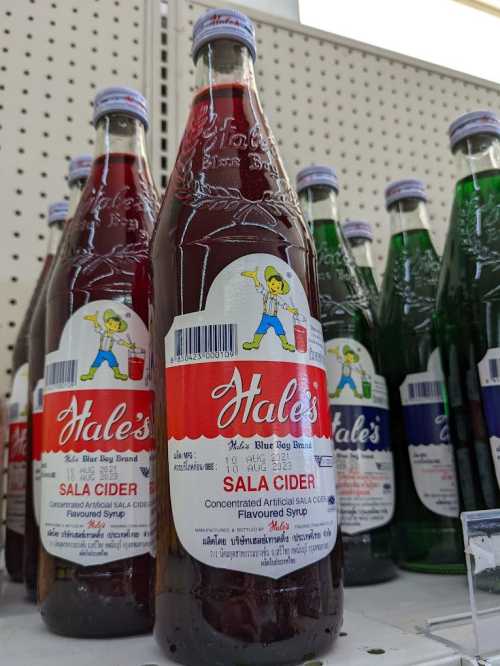 Bottles of Hale's Sala Cider syrup on a store shelf, featuring a colorful label with a cartoon character.