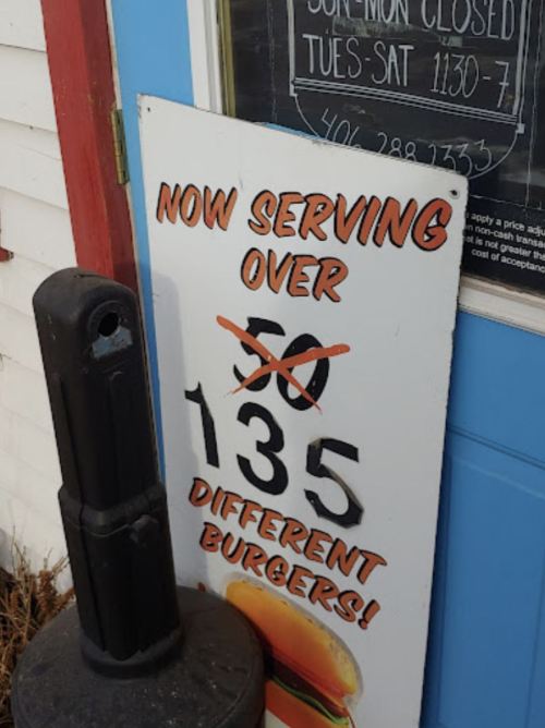Sign outside a restaurant announcing they now serve over 135 different burgers.