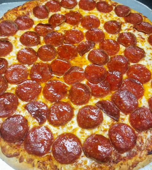 A freshly baked pepperoni pizza with a golden crust and a generous layer of shiny pepperoni slices.