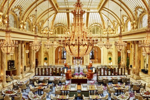 Luxurious restaurant interior with ornate chandeliers, elegant seating, and grand architecture.