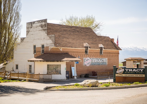 Historic Tracy General Store with a rustic exterior, surrounded by trees and mountains in the background.