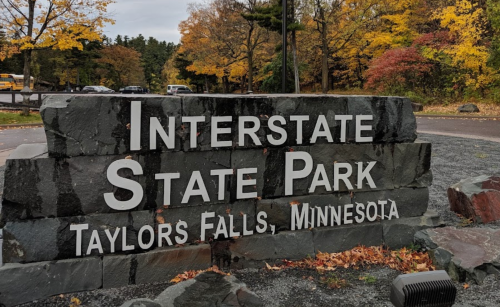 Sign for Interstate State Park in Taylors Falls, Minnesota, surrounded by autumn foliage.