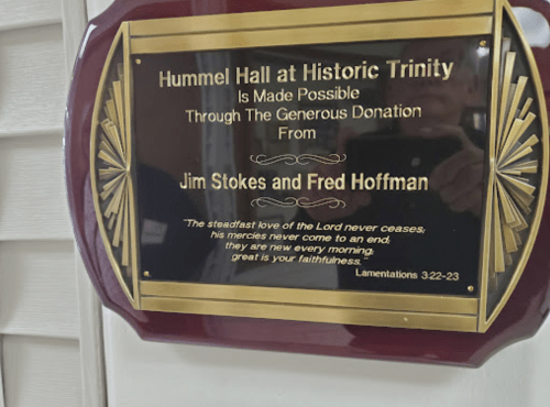 Plaque honoring Jim Stokes and Fred Hoffman for their donation to Hummel Hall at Historic Trinity, featuring a biblical quote.