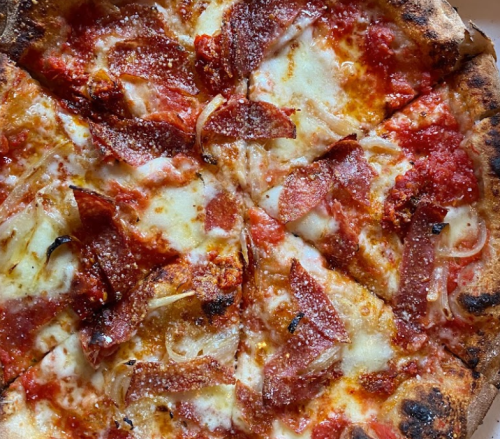 A close-up of a pepperoni pizza with melted cheese, tomato sauce, and crispy crust.