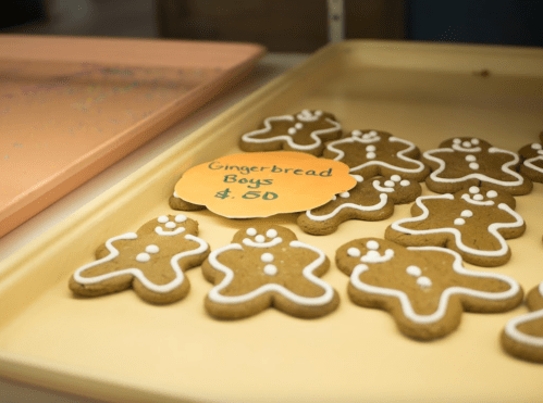 A tray of gingerbread boy cookies with white icing, labeled "Gingerbread Boys" for $0.50.