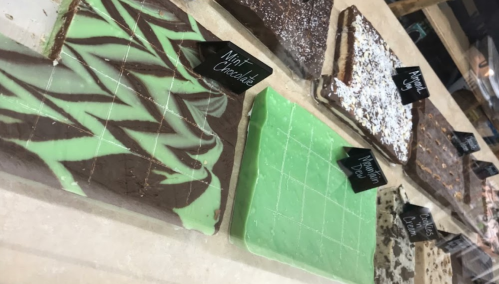 A display of various chocolate bars, including mint chocolate and cookies and cream, with labels on each.