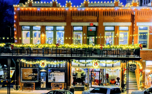 A festive storefront decorated with lights and garlands, showcasing holiday cheer in a charming downtown setting.