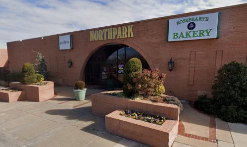 Exterior view of a brick building with signs for "Northpark" and "Rosebeary's Bakery," featuring landscaped planters.