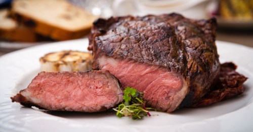 A deliciously marbled steak sliced on a white plate.