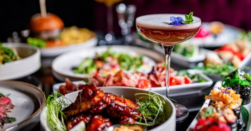 A table full of colorful food and drinks in a restaurant.