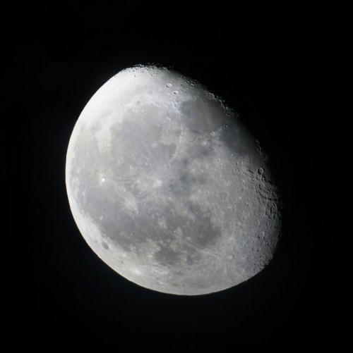 A close-up view of the moon, showcasing its craters and surface details against a black background.