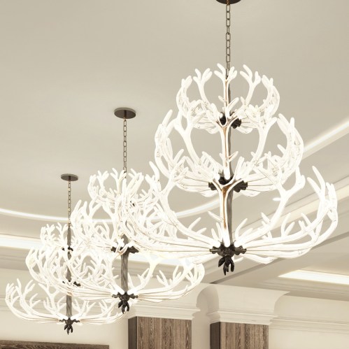 Two elegant chandeliers with antler-like designs hang from a ceiling, illuminating a stylish interior space.