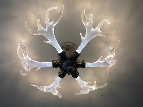 A unique chandelier with antler-shaped light fixtures radiating from a central base.