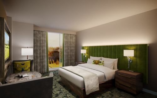 A modern hotel room featuring a king bed, green accent wall, large window, and cozy seating area.