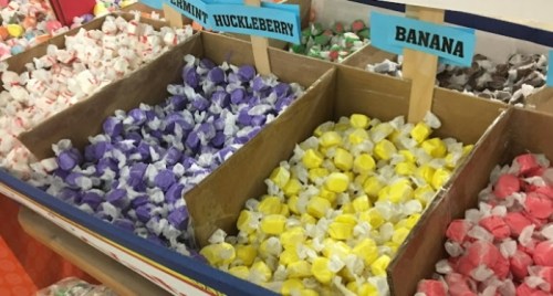 Colorful candy bins filled with assorted taffy flavors: peppermint huckleberry, banana, and more.
