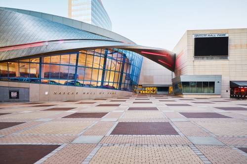 Exterior view of the NASCAR Hall of Fame, featuring a modern design and a spacious plaza in front.