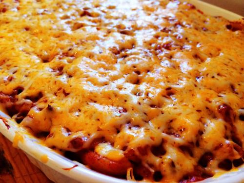 A close-up of a cheesy baked dish with a golden, melted cheese topping, likely a casserole or pasta bake.