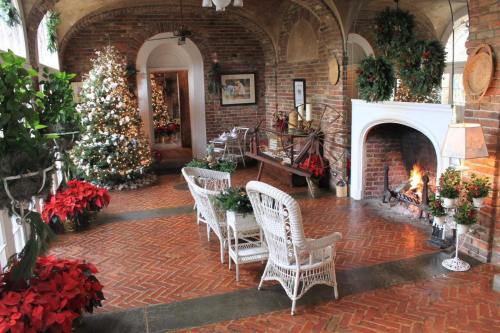 Cozy room decorated for the holidays, featuring a Christmas tree, poinsettias, and a warm fireplace.