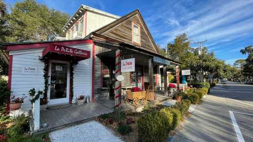 Charming art gallery with a wooden exterior, festive decorations, and a welcoming porch on a sunny street.