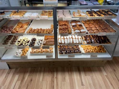 A display case filled with various types of donuts and pastries, including glazed, chocolate, and cream-filled options.