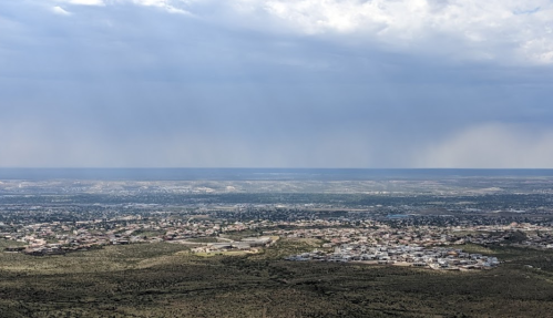A panoramic view of a sprawling landscape with a distant horizon under a cloudy sky.