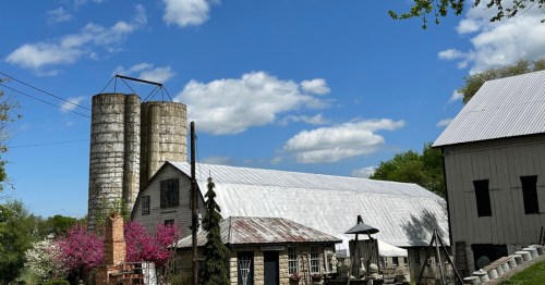 the main barn building of chartreuse & co., a unique store with antiques and gifts in frederick maryland under a blue sky