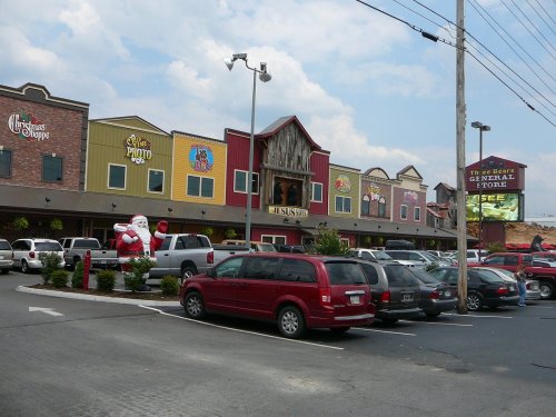 A festive general store with colorful signage, a Santa decoration outside, and a parking lot filled with cars.