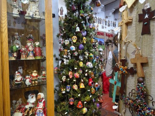 A festive display featuring a decorated Christmas tree surrounded by colorful ornaments and handcrafted decorations.