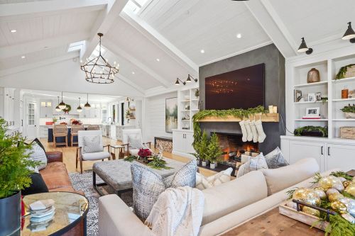 Cozy living room with a fireplace, festive decor, and modern furnishings, featuring a bright, open layout.