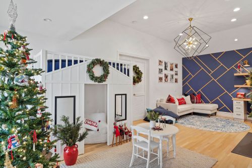 Cozy holiday-themed playroom with a tree, a playhouse, and festive decor on the walls and furniture.