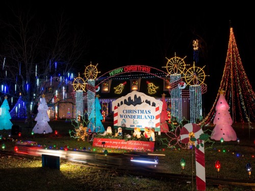 A festive display of colorful Christmas lights, trees, and decorations, creating a magical holiday atmosphere at night.
