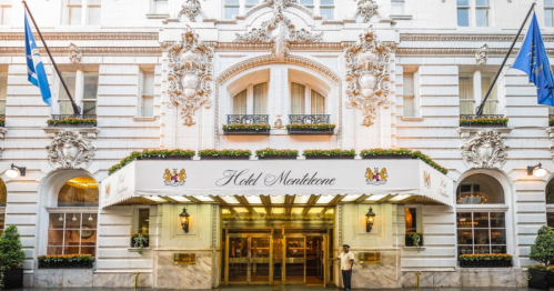 Elegant hotel entrance with ornate architecture, flags, and a marquee reading "Hotel Monteleone."