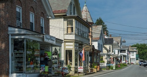 A quaint street lined with charming shops and historic buildings under a clear blue sky.