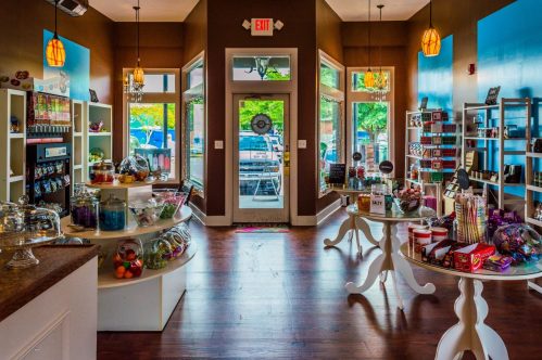 Brightly lit shop interior with colorful displays, shelves of products, and a welcoming entrance.