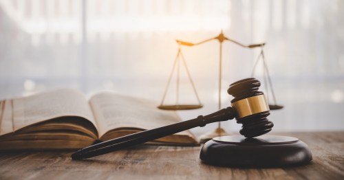 A judge's gavel next to an open book and scales of justice, representing unusual Georgia laws.