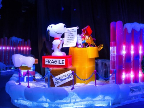 Snoopy and friends in a colorful ice sculpture scene with holiday decorations and a "Fragile" sign.
