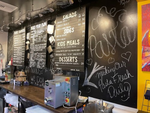 Chalkboard menu displaying food options like salads, sides, and desserts in a casual eatery setting.